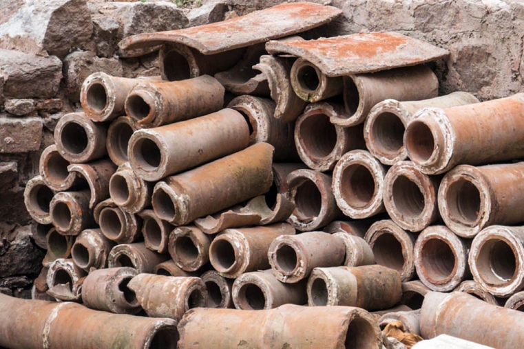 Ancient Roman sewer pipes stacked against a stone wall. iSidhe/iStock/Getty Images